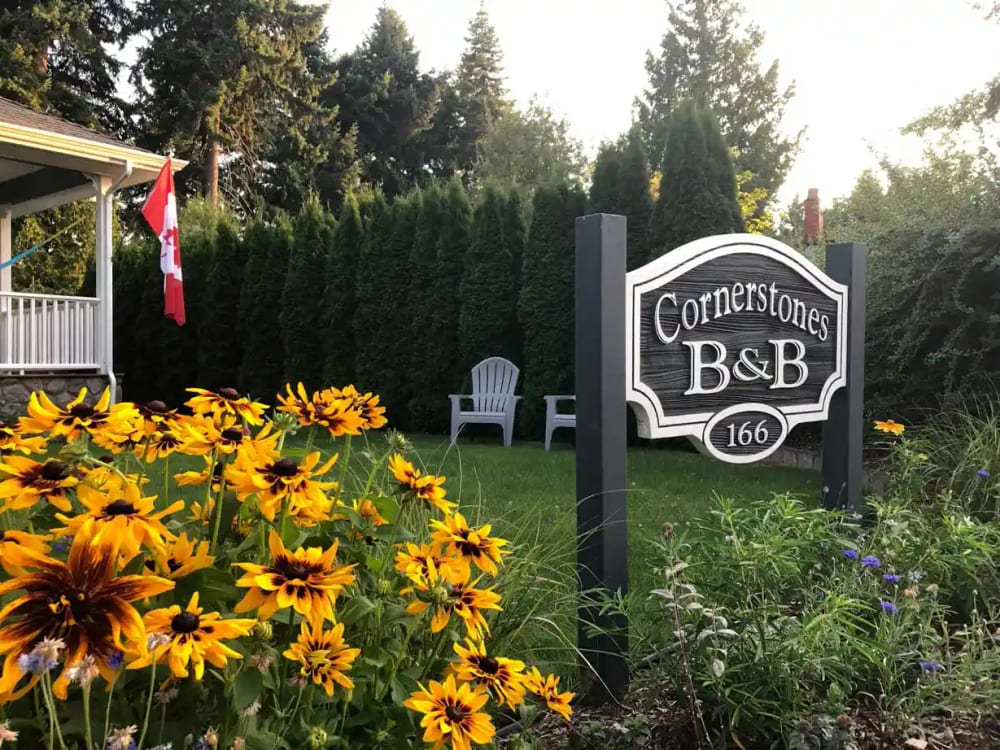 The carved Cornerstones B&B sign at number 166, standing in a bed of black-eyed susans.