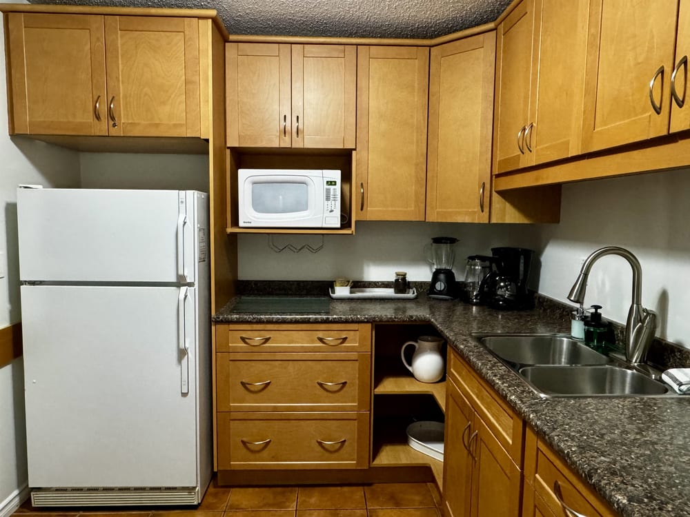 A full kitchen with island, stove, oven and full-size fridge.