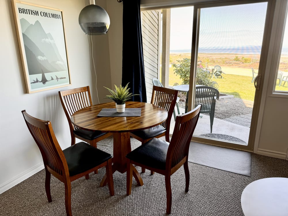 A dining table set for four beside the window.