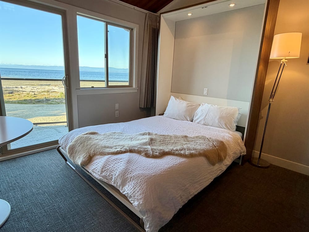 The living room below the loft, sofa facing the window and the balcony door.
