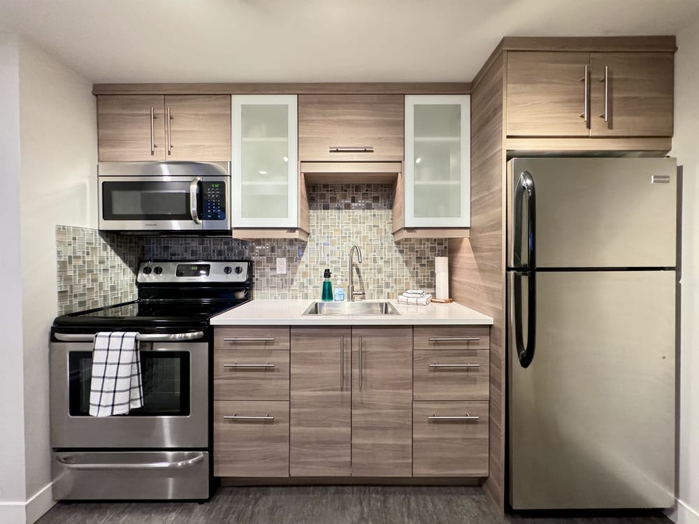 A full kitchen with an island, stove, oven and full-size fridge.