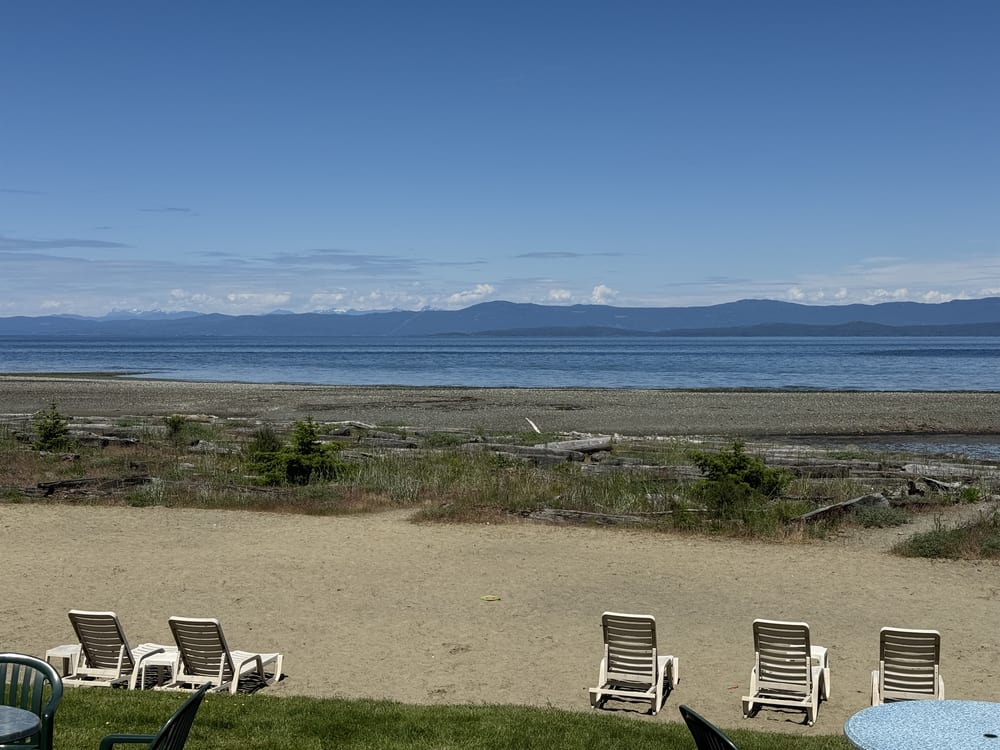 The resort’s private sandy beach with lawn chairs set out above the tide line.